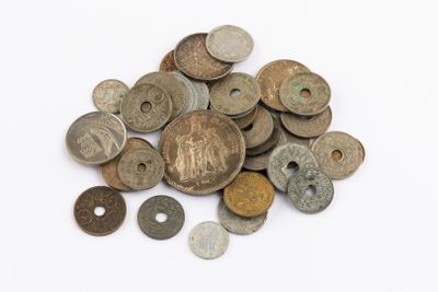 a pile of old coins on a white surface