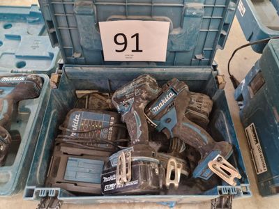 de nombreux outils dans une boîte bleue posée par terre