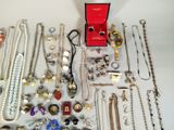 many different types of necklaces and bracelets laid out on a table