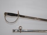 an old sword with a metal handle sitting on top of a white surface