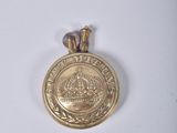 Gros plan sur une médaille d'or ornée d'une couronne