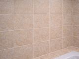 a bathtub in a tiled bathroom with a shower head