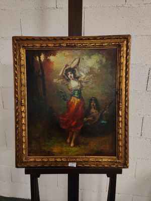 Une peinture à l'huile représentant une femme en robe rouge est posée sur un chevalet.
