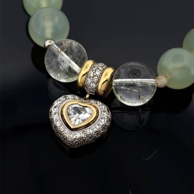 Collier avec un cœur en cristal et en or sur un fond noir