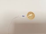 a gold coin on a white plate with a white cord
