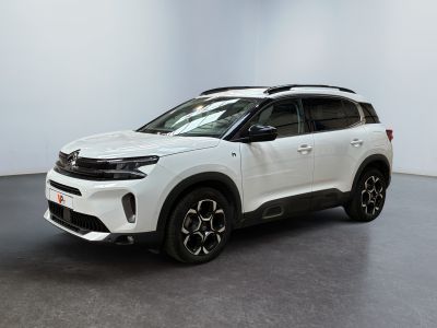 un SUV blanc garé dans une pièce au sol noir