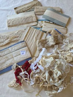 many pieces of lace on a bed spread out on the bed
