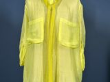 neon yellow shirt on a mannequin stand against a blue wall