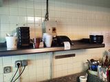 a kitchen counter with a bunch of clutter on it