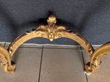 a gold frame on the floor of a room
