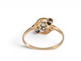 an image of a gold ring with a white diamond and blue sapphires