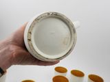 a person holding a cup with a lot of cups in front of it