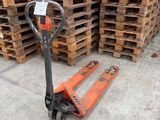 an orange forklift is sitting in front of a stack of pallets