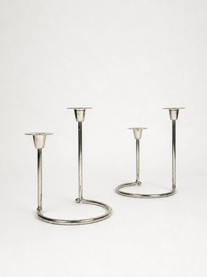deux bougeoirs en argent sur fond blanc, avec un fond blanc