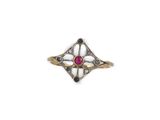 a close up of a ring with a red stone in it