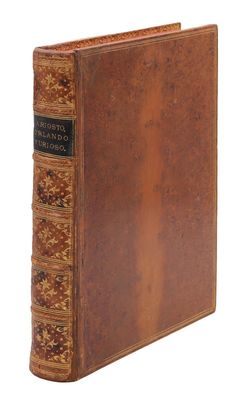 un vieux livre à la couverture brune et à la bordure dorée