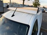 a white car parked in a parking lot with a roof rack on top