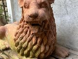 a statue of a lion that is sitting on a wooden bench