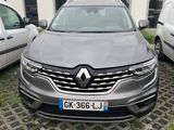 une voiture grise garée devant un immeuble, à côté d'autres voitures