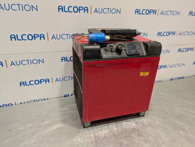 a red machine sitting on top of a floor next to a wall