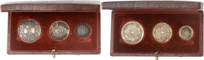 two silver coins in a wooden box on a white background