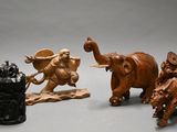 trois figurines d'éléphants et un lion posés sur une table