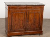 une vieille armoire en bois avec un plateau en marbre, posée sur un parquet