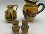 quatre tasses et un pichet posés les uns à côté des autres sur une table