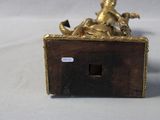 a gold figurine of a woman riding a horse on a box