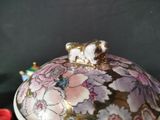a small bowl with a lid that has a flower design on it