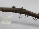 an old rifle with a wooden barrel and a metal stand