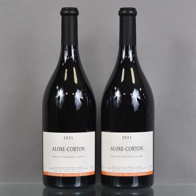 two bottles of wine sitting on top of a table next to each other