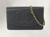 une pochette Chanel en cuir noir avec une chaîne dorée