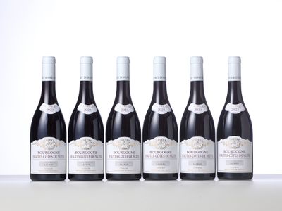 six bottles of wine are lined up in a row on a table