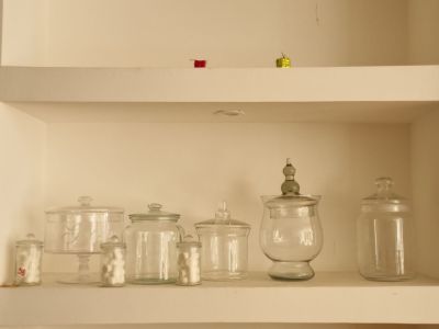 de nombreux bocaux en verre alignés sur une étagère dans une pièce