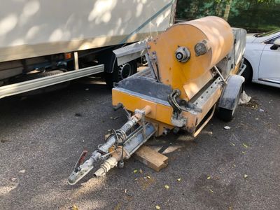 a trailer with a boat attached to it parked in a parking lot