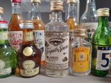 many bottles of alcohol sitting on a counter top
