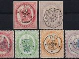 six different colored stamps on a black surface with a black background
