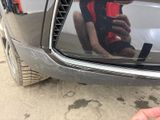 a person holding a cell phone in front of a car