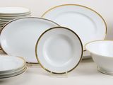 many white and gold plates and bowls on the table