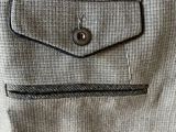 the back pocket of a jacket with a button on it