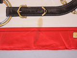 a picture of a red and white blanket with a black and gold belt on it