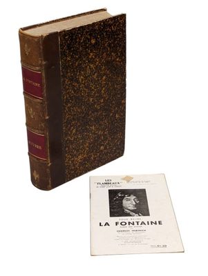 un vieux livre posé sur une table à côté d'un livre