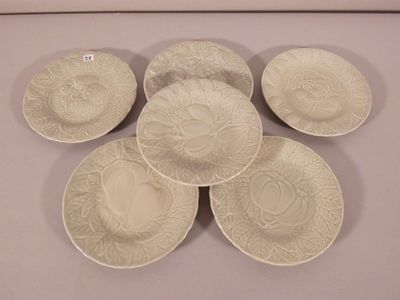 six white plates with designs on them are arranged on a table