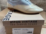 beige and blue shoes on top of a cardboard box on a table