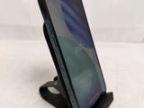 a close up of a cell phone on a stand on a white surface
