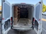 the back of a white van with its doors open in a parking lot