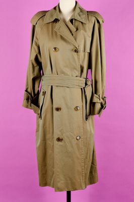 un trench-coat marron posé sur un mannequin, devant un fond rose