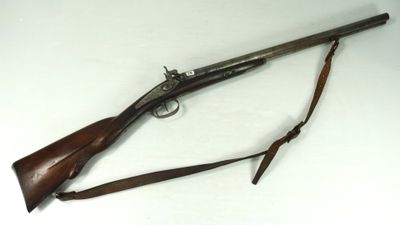 un vieux fusil muni d'une crosse en bois et d'une bretelle en bois
