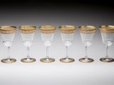 a set of six wine glasses with gold rims